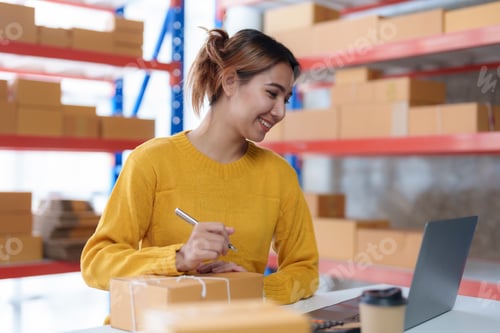 Preview: Young Asian online business owner woman is preparing a parcel box to prepare the package for deliver
