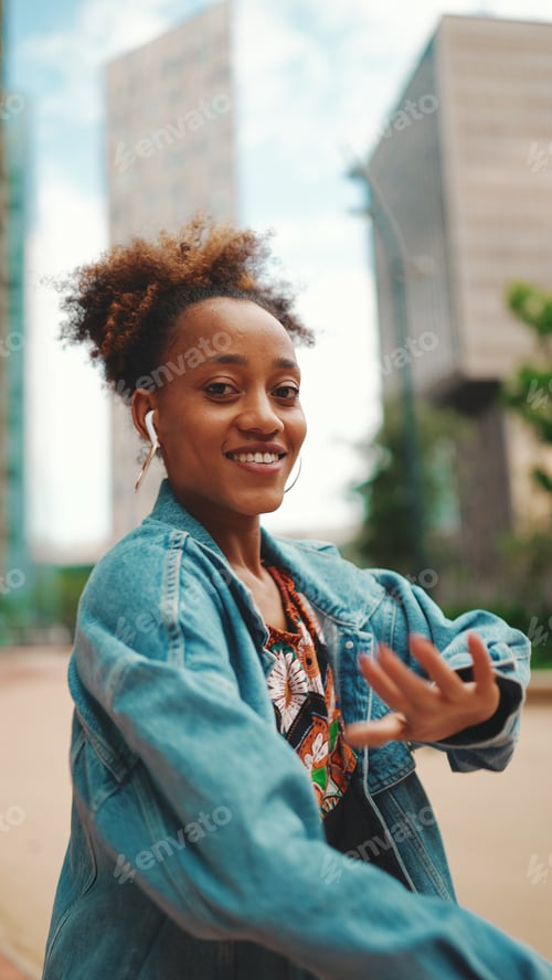 Preview: Closeup, smiling African listening to music on headphones and dancing outdoors.