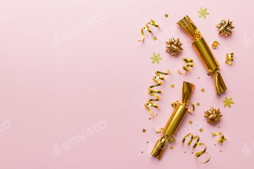 Preview: Christmas crackers with shiny confetti on color background, top view, copy space