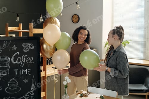 Preview: Two women decorating cafe with balloons