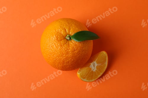 Preview: Ripe mandarin with leaf on orange background
