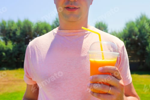 Preview: Man drinking vegetable smoothie after fitness running workout on summer day.