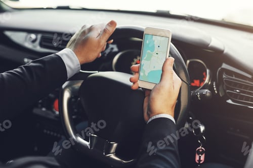 Preview: Closeup shot of an unrecognizable businessman using his cellphone while driving