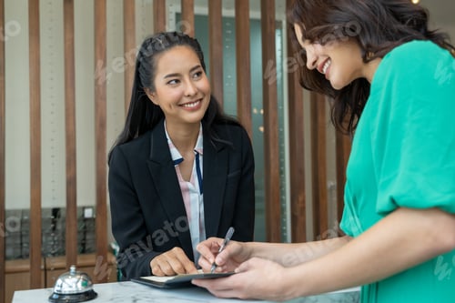 Preview: Check in hotel,Young woman checking in at counter with reception at hotel.