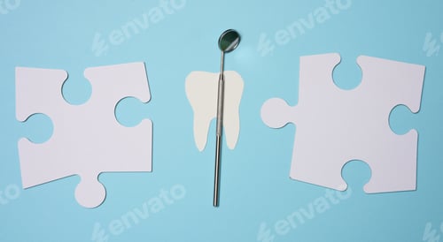Preview: Dentist's medical mirror and white paper puzzles on a blue background