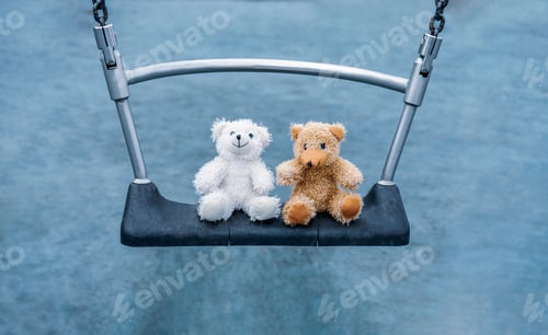 Preview: Two Teddy bears sitting on swing in playground, Happy Brown and Cute White Bear sitting together