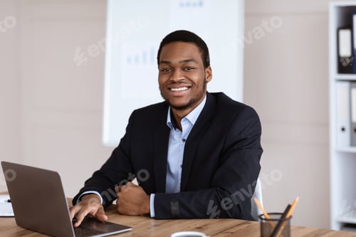 Preview: Happy african american businessman looking at camera