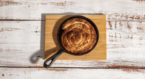 Preview: Cinnamon bun in black metal pan on the wooden table