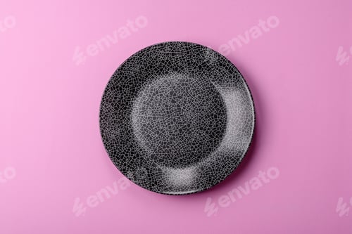 Preview: An empty round ceramic plate on a pink background as a kitchen utensil. An empty plate