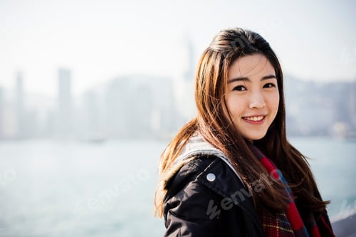 Preview: Portrait of young woman wearing checked scarf and leather jacket, looking at camera