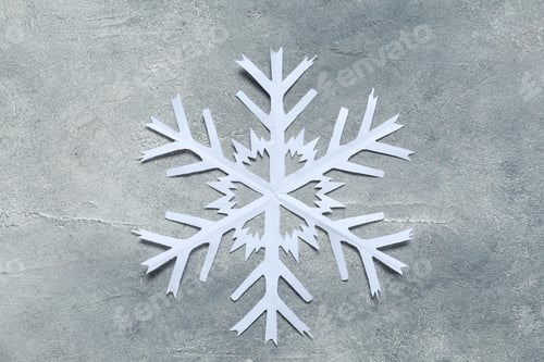 Preview: One beautiful paper snowflake on grey table, top view