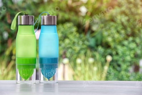 Preview: Sports water bottles on table against blurred background. Space for text
