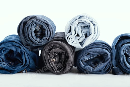 Preview: Stack of different rolled jeans on white background