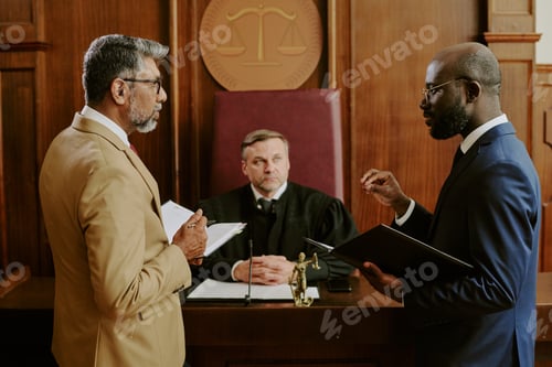 Preview: Middle Aged Caucasian Judge Observing Lawyers Discussing Case in Courtroom