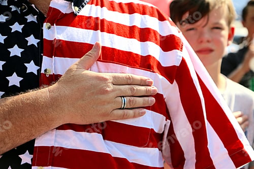 Preview: Minimalistic image of a man with his hand over his heart during the national anthem