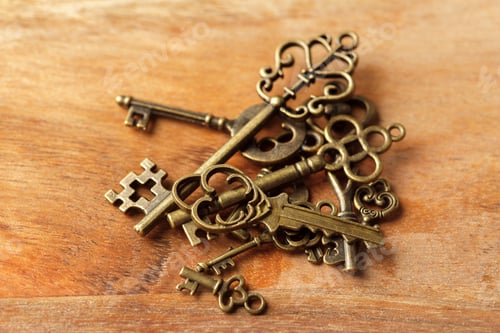 Preview: Various antique keys arranged on a wooden surface showcasing intricate designs and details