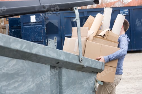 Preview: Teenage boy carrying cardboard waste to recycling bin