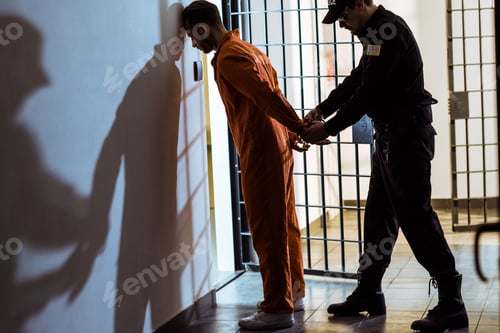 Preview: side view of prison officer wearing handcuffs on prisoner