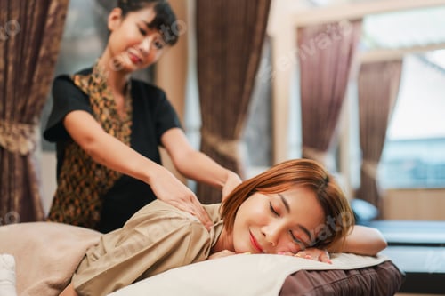 Preview: Relaxed woman receiving a professional massage at a tranquil spa.