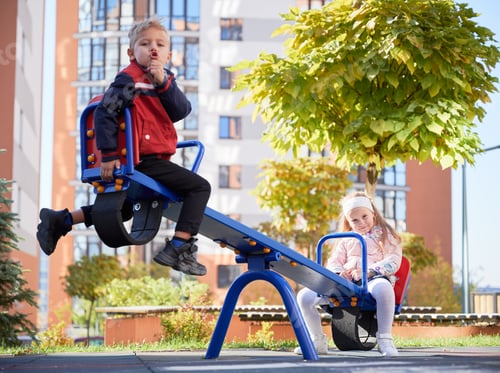 Preview: Cheerful brother and sister having fun at playground.