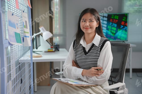 Preview: Confident businesswoman holding clipboard and smiling in modern office