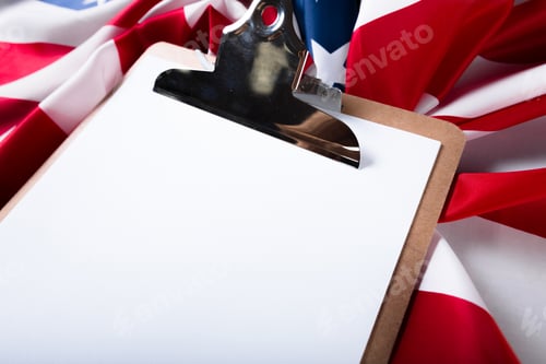 Preview: blank clip board and USA flag on wooden background