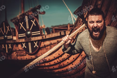 Preview: Viking with axe standing near drakkar on the seashore.