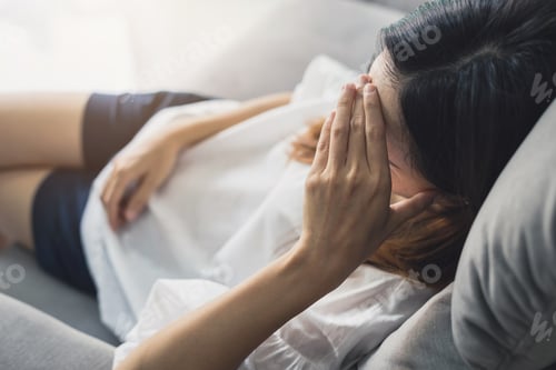 Preview: Depressed young woman holding hand on head