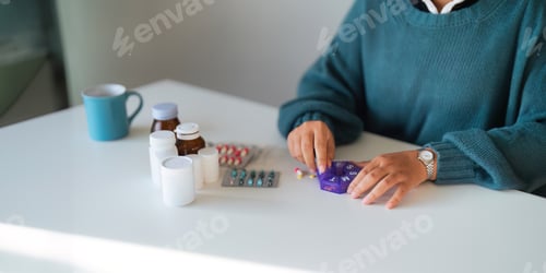 Preview: Women organizing his medication into pill dispenser. female taking pills from box. Healthcare and