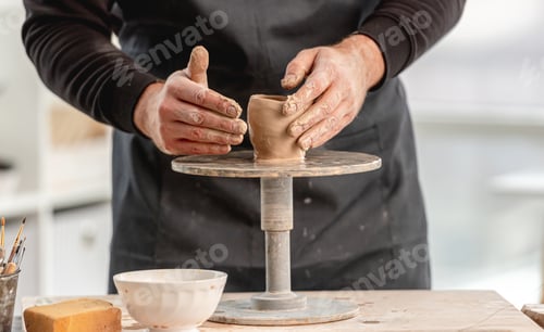 Preview: Man using pottery wheel for molding