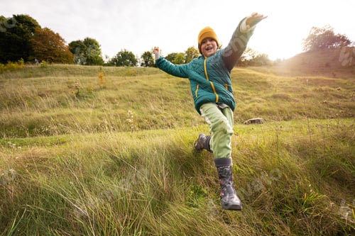 Preview: Boy having fun run and jump outdoor near forest.