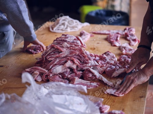 Preview: Crop man slicing meat on table