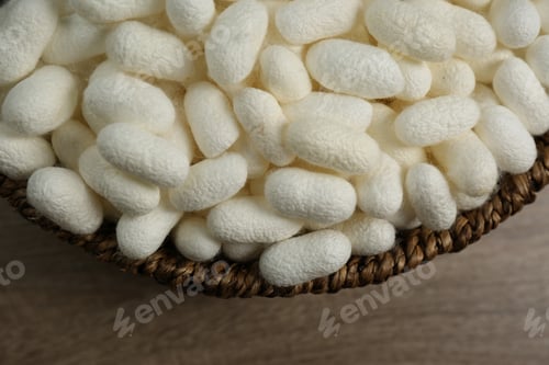 Preview: White silk cocoons in bowl on wooden table, closeup