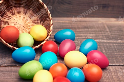 Preview: Colorful Easter Eggs Spilled from Basket on Table