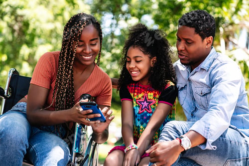 Preview: Woman in a wheelchair at the park with family.