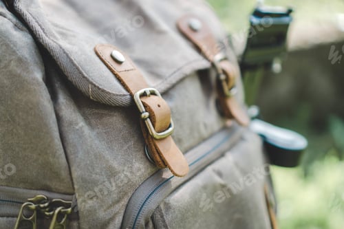 Preview: Closeup of a modern backpack with leather straps under the sunlight with a blurry background