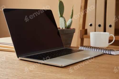 Preview: laptop with blank screen and cup of coffee at table