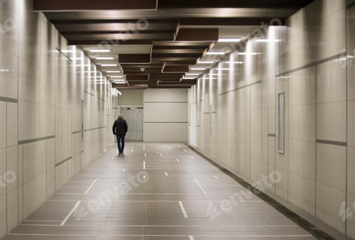 Preview: A man from behind walking alone in the subway corridor under electricity lights