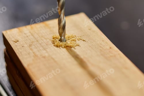 Preview: Close up of drilling into wood with screw twisted into place, metal drill bit