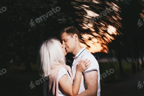 Preview: Young happy couple in love kissing in the night park. Photo with flash effects