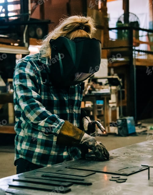 Preview: A female welder welding in a metal shop
