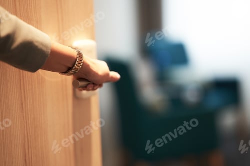 Preview: Half-open door of a hotel bedroom with hand