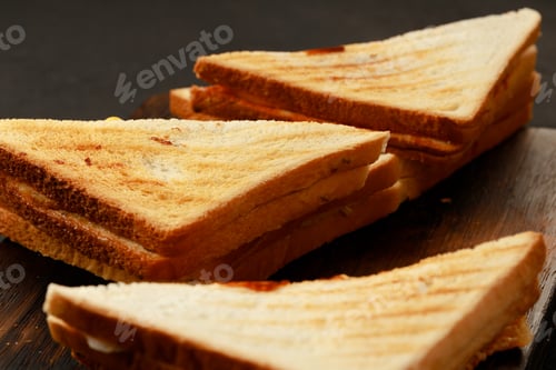 Preview: Assortment of toasted triangle sandwiches on wooden board
