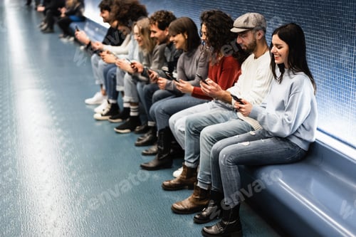 Preview: Young multiracial friends having fun using mobile phones inside subway station