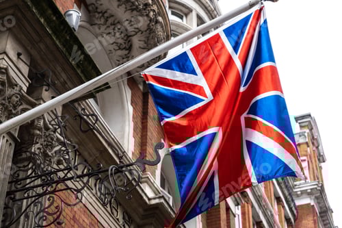 Preview: Flag of the United Kingdom on a building under the sunlight with a blurry background