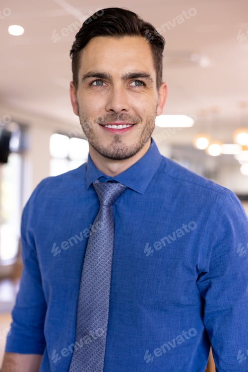 Preview: Happy caucasian businessman wearing blue shirt in modern office