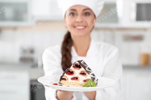 Preview: Professional female chef with plate of delicious dessert in kitchen