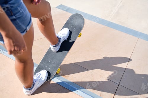 Preview: unrecognizable young afro girl stepping on a skateboard on top of a skate ramp