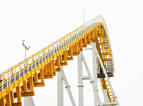 Preview: Thrilling yellow and white roller coaster descending on an amusement park ride