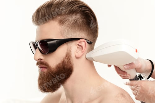 Preview: young man receiving laser skin care on neck isolated on white. healthy lifestyle man concept